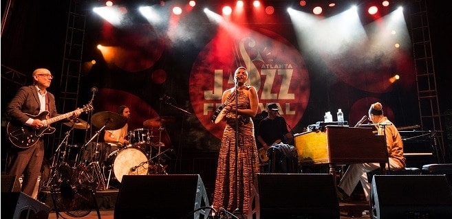 Atlanta Jazz Festival artist Lizz Wright on stage performing with her band.