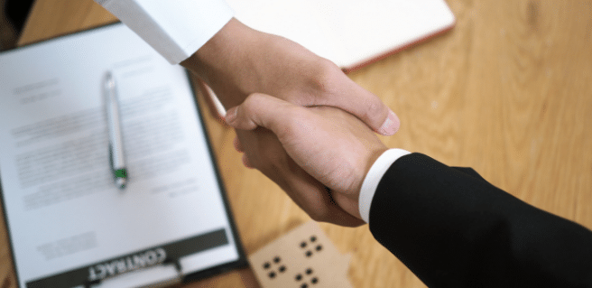 handshake over home cutout and paperwork to depict homebuyer tips for first home