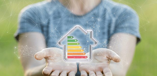 person holding an image of an energy efficient home in their hands