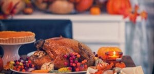 Table is set up for celebrating Thanksgiving. On the table is a traditional roasted turkey with side dishes and autumn decoration. Atlanta restaurants open on Thanksgiving