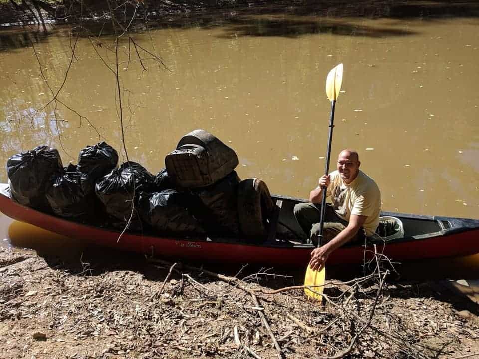 Bryan Topper removing trash from Little River via canoe during The Great Lake Allatoona Cleanup