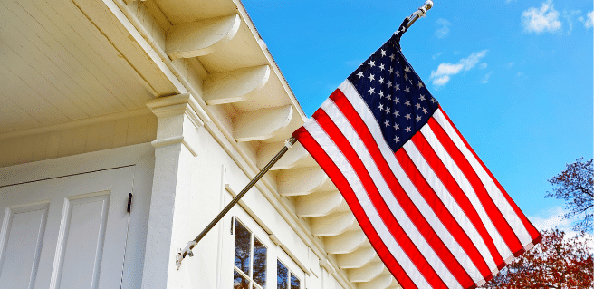 home with American flag to depict U.S. housing market