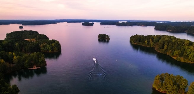 Lake Lanier with a boat on it at sunset homeowners at Arden on the Lake can enjoy this view year-round