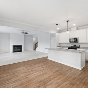 Stonegate interior kitchen and living room with white cabinetry and white walls