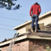 man standing on a roof - roofing mistakes to avoid
