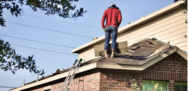 man standing on a roof - roofing mistakes to avoid