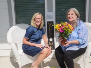 Gayle Guht and Kolter Homes New Homes Guide Liz Woodruff sitting on a front porch holding flowers