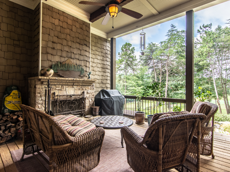 Harcrest Homes outdoor living for the fall season with a firelace on a screened in porch