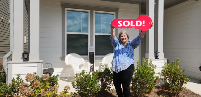 First Homeowner holding up a SOLD sign in Oak Hill Reserve by Kolter Homes
