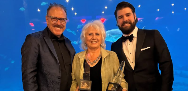 Kittle Homes posing at the Georgia Aquarium with two OBIE awards