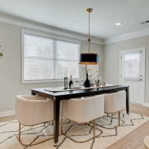 Traton Homes Gates at Hamilton Grove Dining Room with black table, beige chairs, black pendant light and beige walls