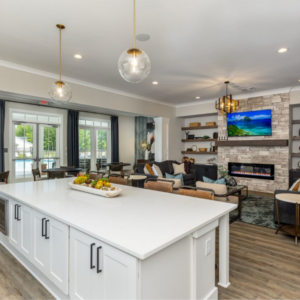 clubhouse interior with pendant lighting, white kitchen island and brick fireplace near Savannah