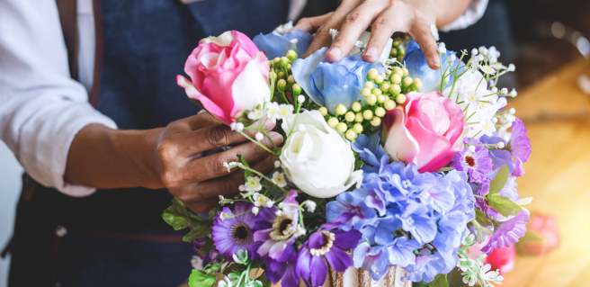 woman arranging a colorful bouquet of flowers