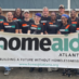 a group of HomeAid volunteers poses with HomeAid Atlanta banner on Care Day