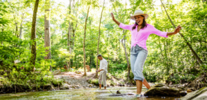 a couple playing in a creek near their dream home at The Vineyard at Yukon