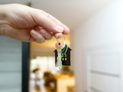 hand holding house keys in front of door